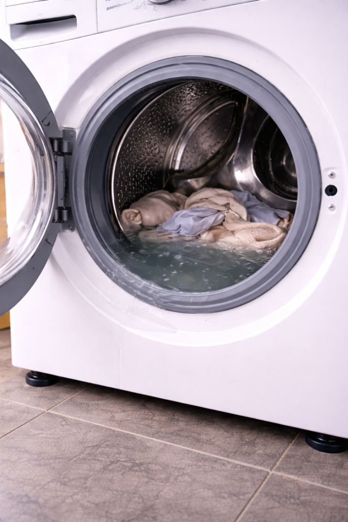 Lave-linge arrêté avec de l’eau visible dans le tambour